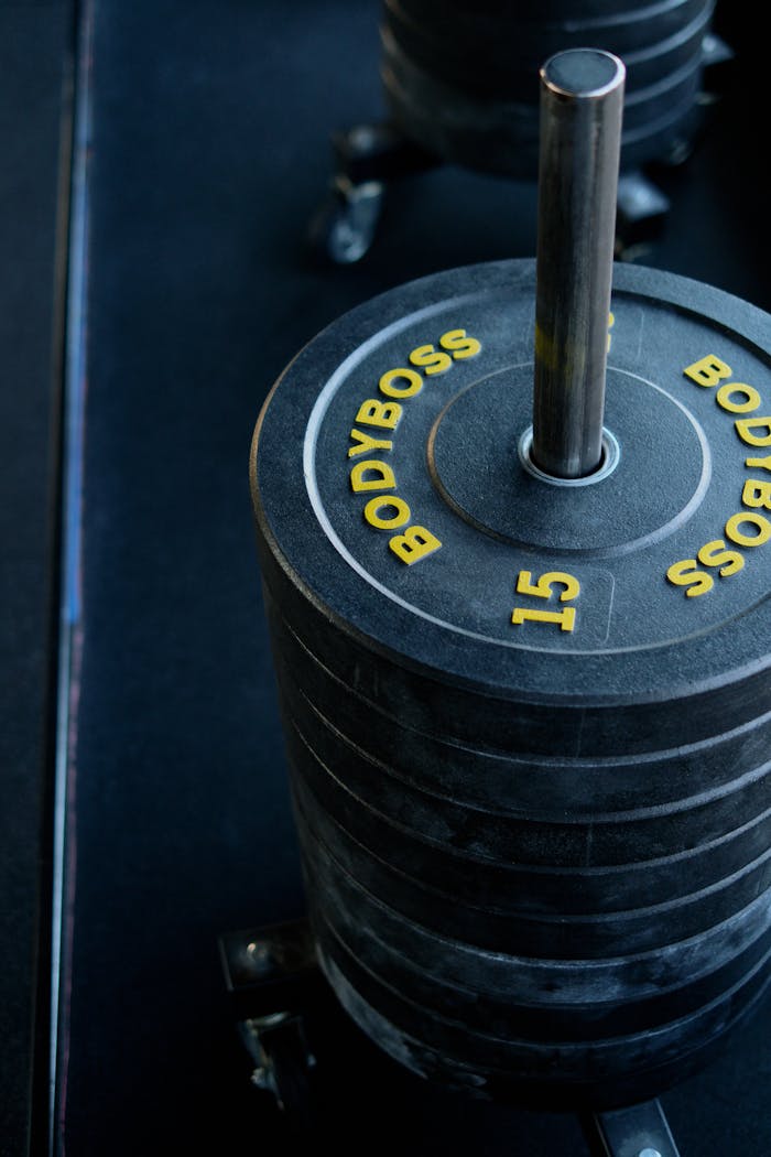 Closeup of Bodyboss weight plates stacked on a rack in a gym.