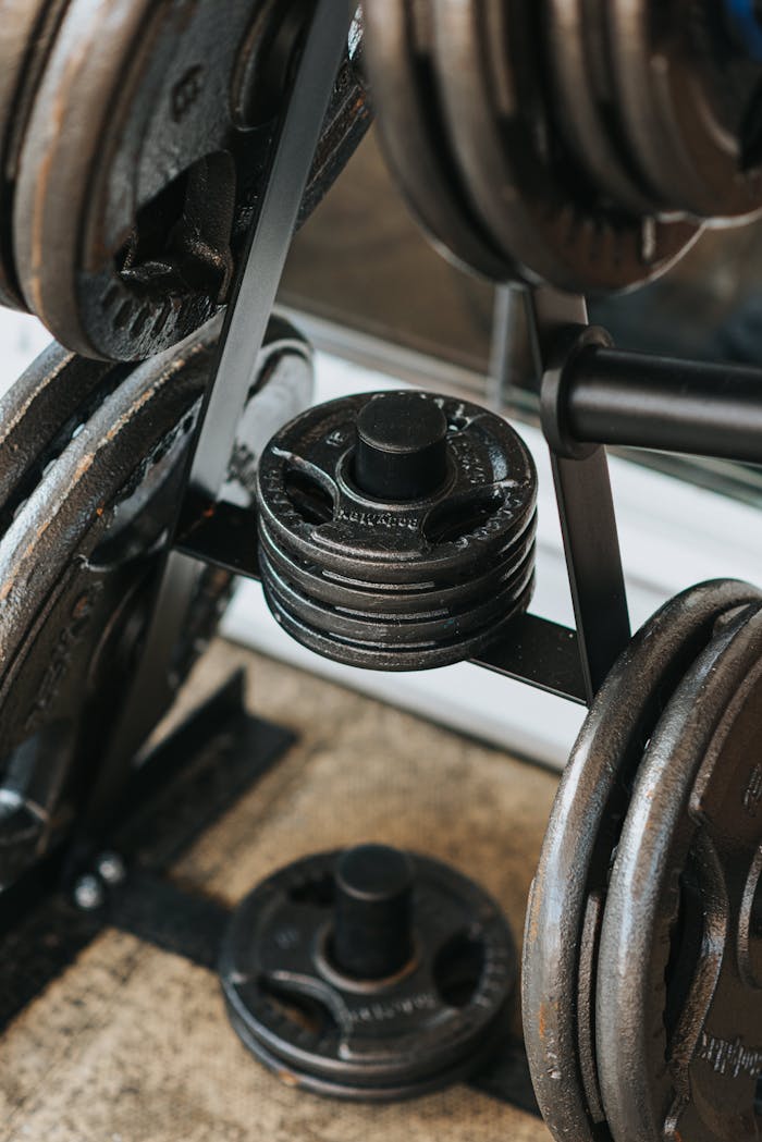 Close-up shot of metal weight plates stacked on a gym rack indoors.